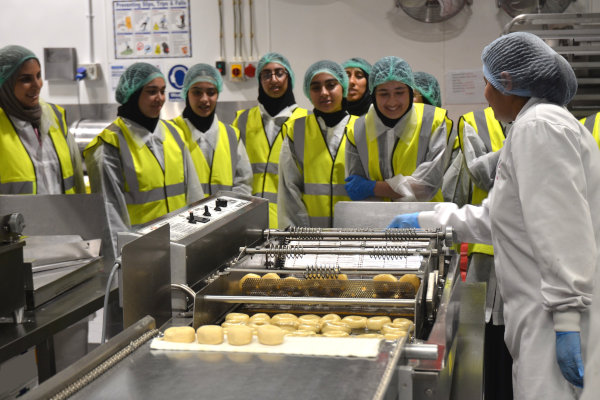 Pupils watch the doughnut frying stage in the factory.